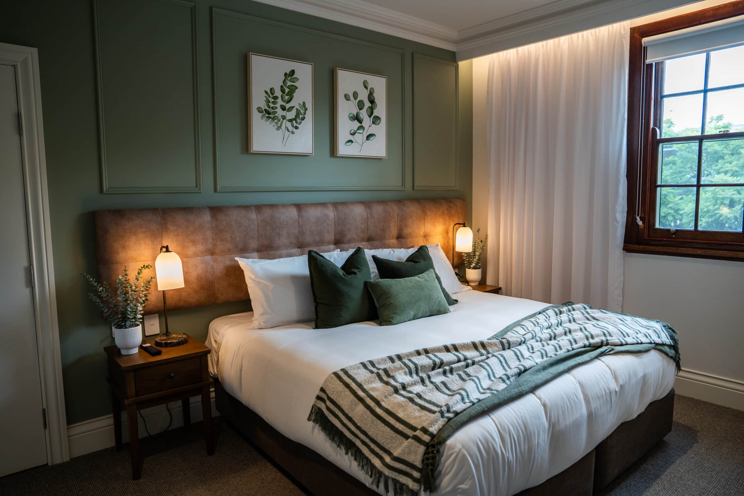 Closer view of the layered window furnishing and styled bed setting.